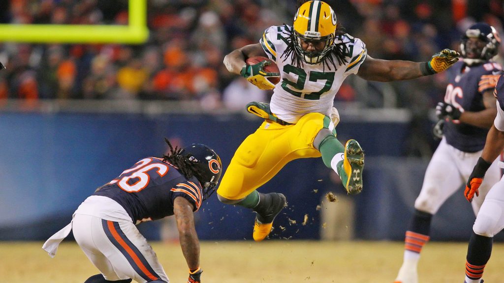 Dec 29, 2013; Chicago, IL, USA; Green Bay Packers running back Eddie Lacy (27) leaps over Chicago Bears cornerback Tim Jennings (26) during the second quarter at Soldier Field. Mandatory Credit: Dennis Wierzbicki-USA TODAY Sports